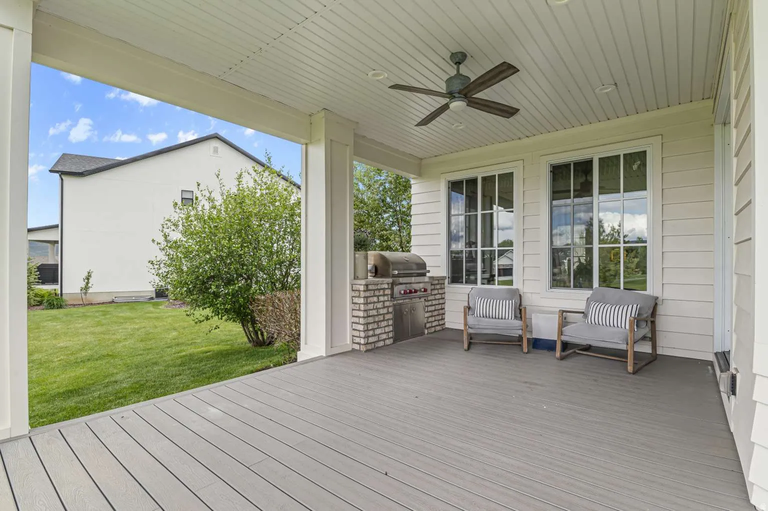 Deck featuring a lawn, a grill, and ceiling fan