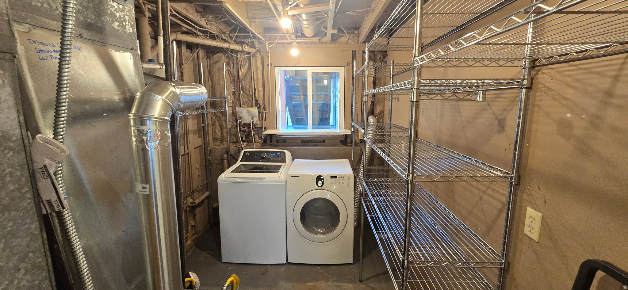 Laundry area with concrete floors and separate washer and dryer