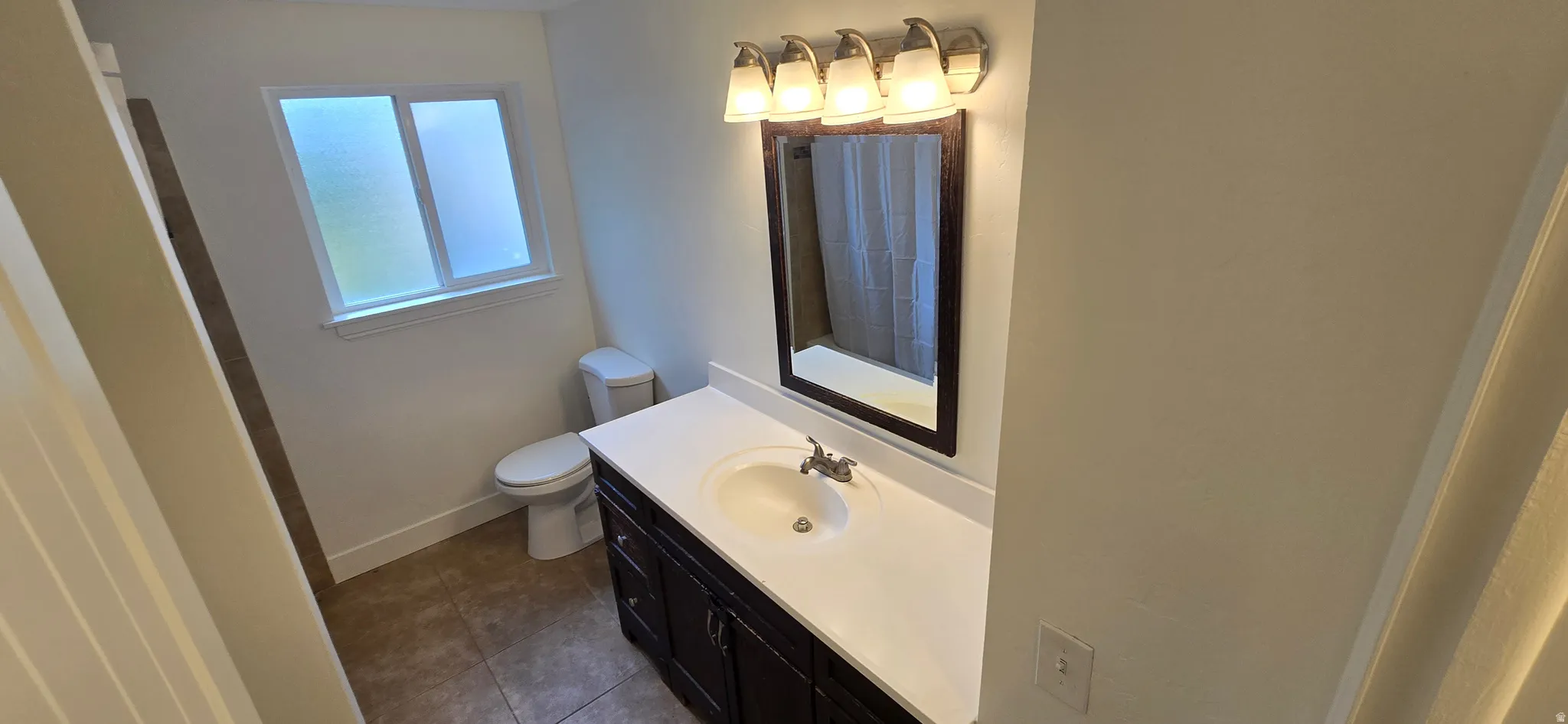 Full bath featuring vanity and dark tile patterned floors