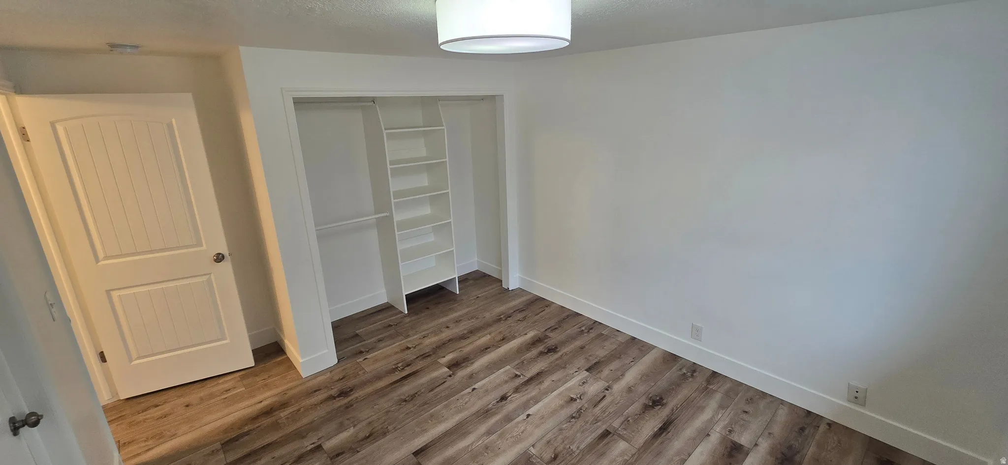 Unfurnished bedroom featuring a closet and wood finished floors