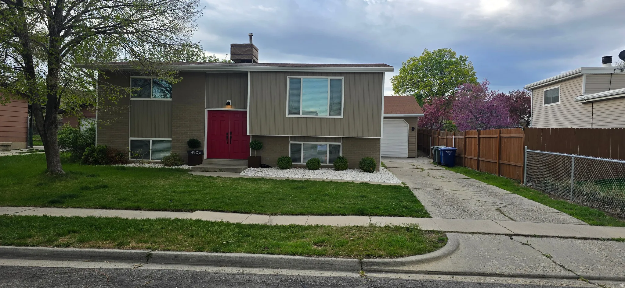 Split foyer home featuring brick siding, a chimney, and driveway