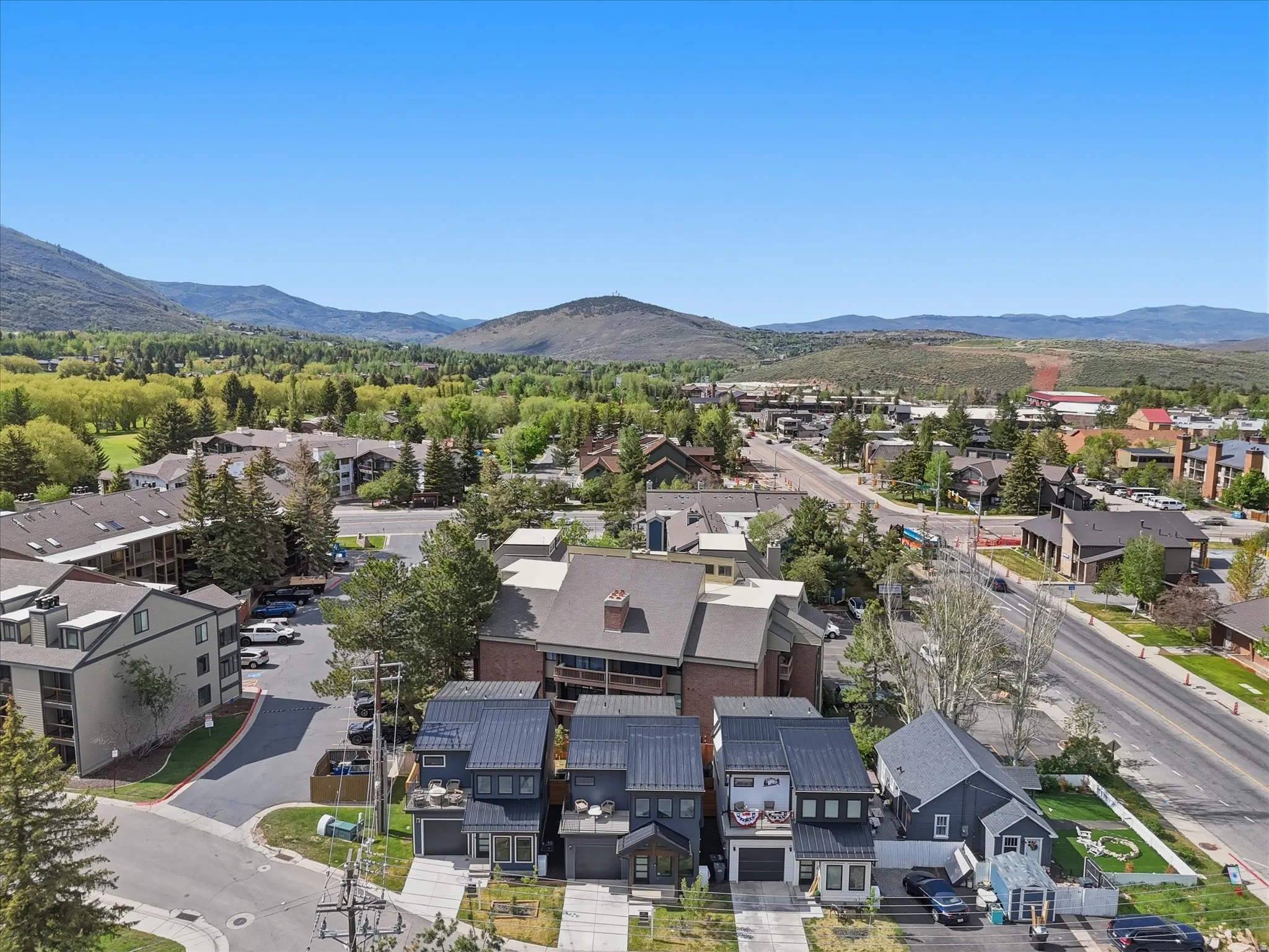 Modern townhomes featuring dark siding, metal roofs, and attached garages