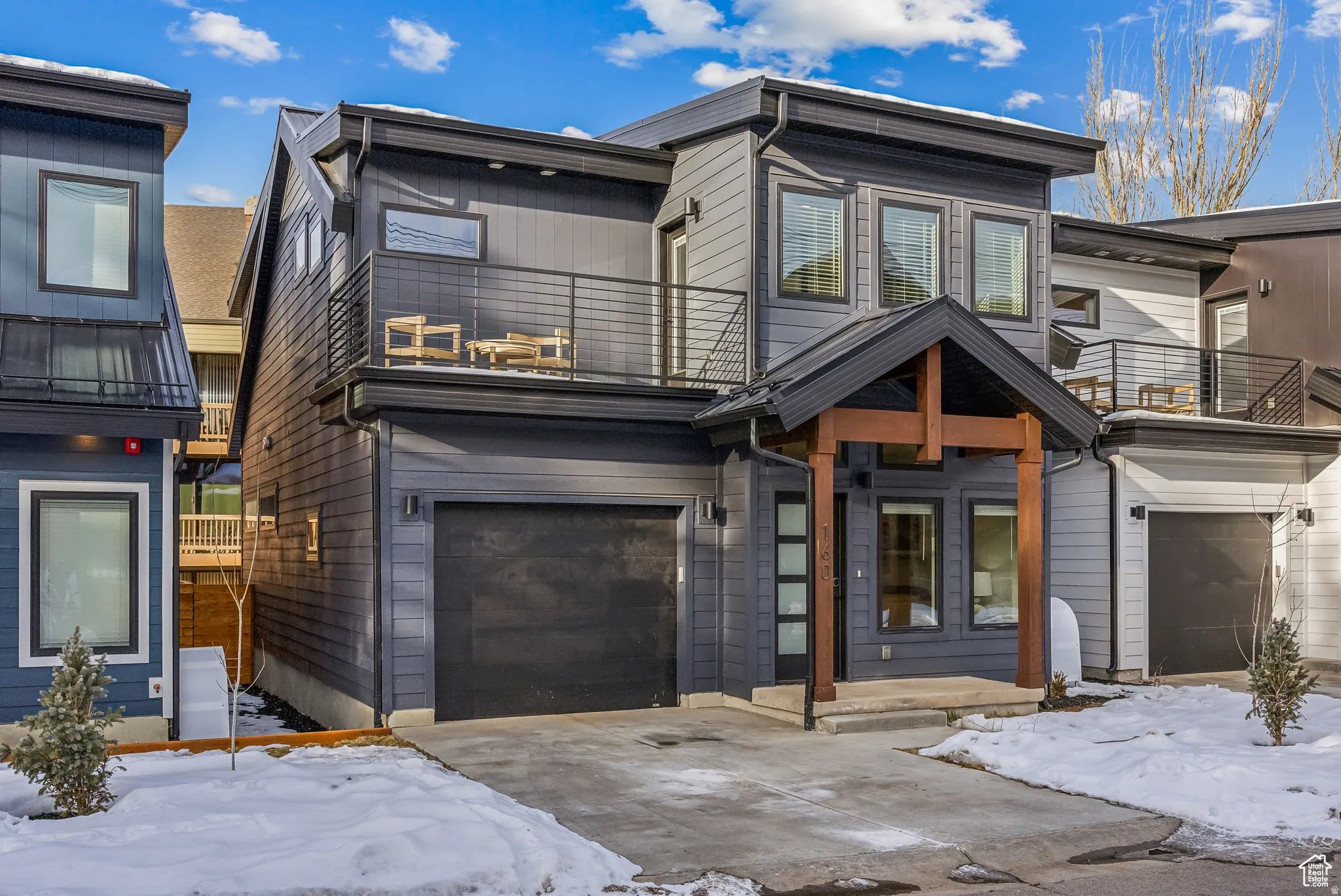 View of front of house featuring a balcony and a garage