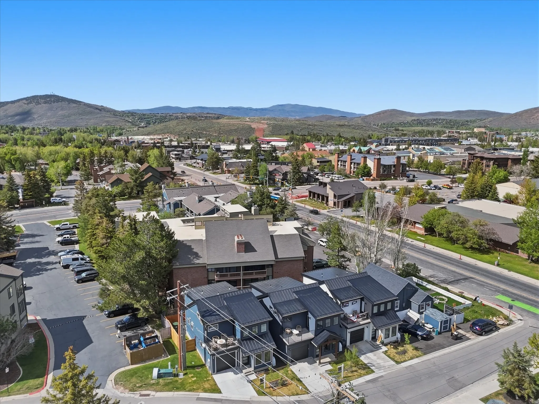 Modern townhome facades featuring dark siding, individual balconies, and attached garages