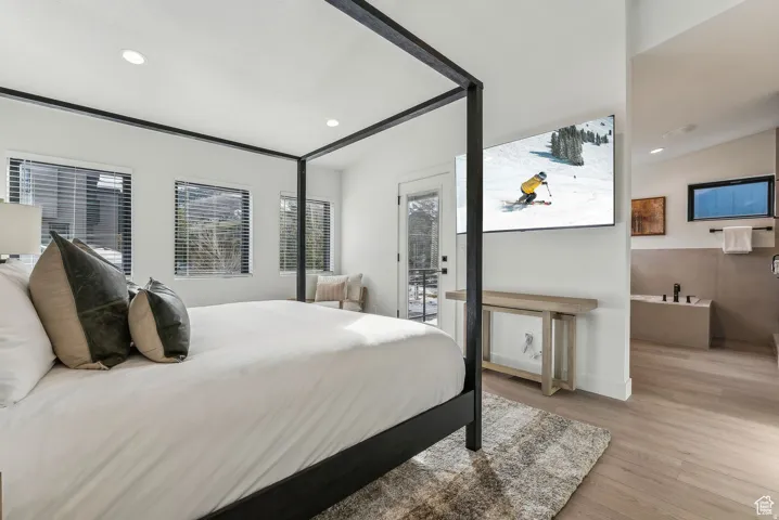 Bedroom with light wood-type flooring, recessed lighting, and access to exterior
