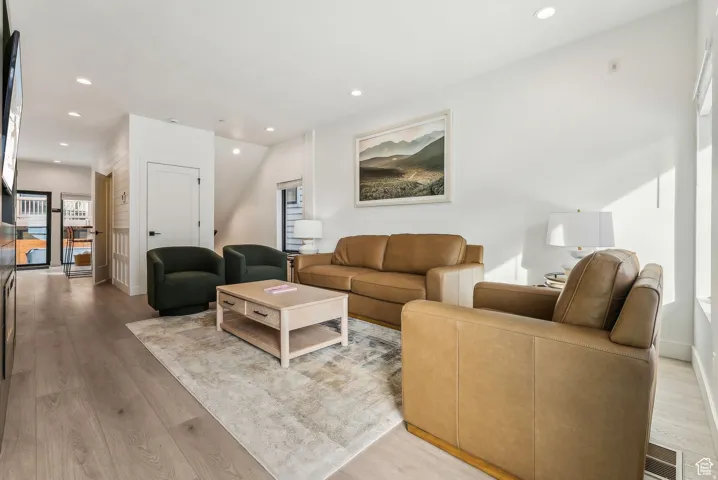 Living room with light wood finished floors and recessed lighting