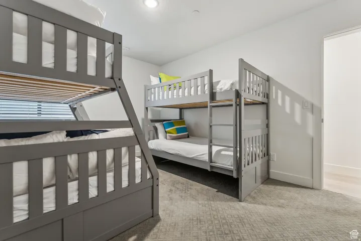 Bedroom featuring light carpet and baseboards