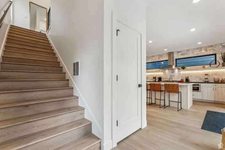 Staircase featuring recessed lighting and wood finished floors