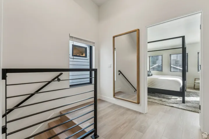 Hall with an upstairs landing and light wood-style floors