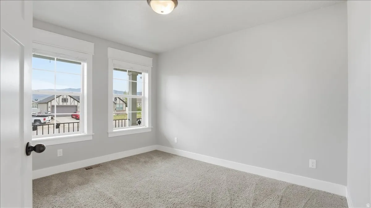 Spare room with light carpet and baseboards