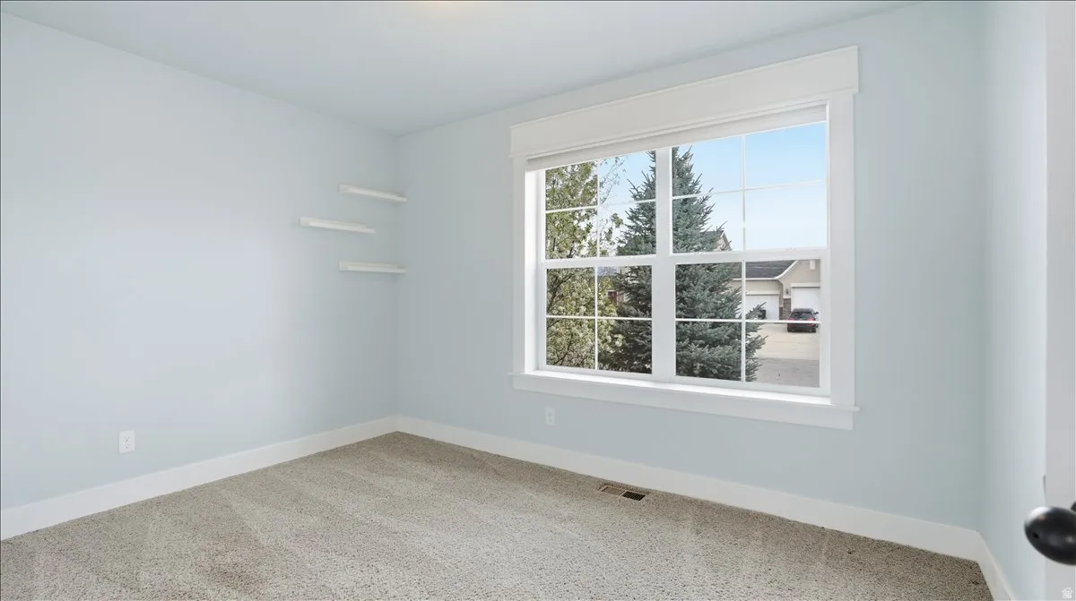 Carpeted spare room with baseboards