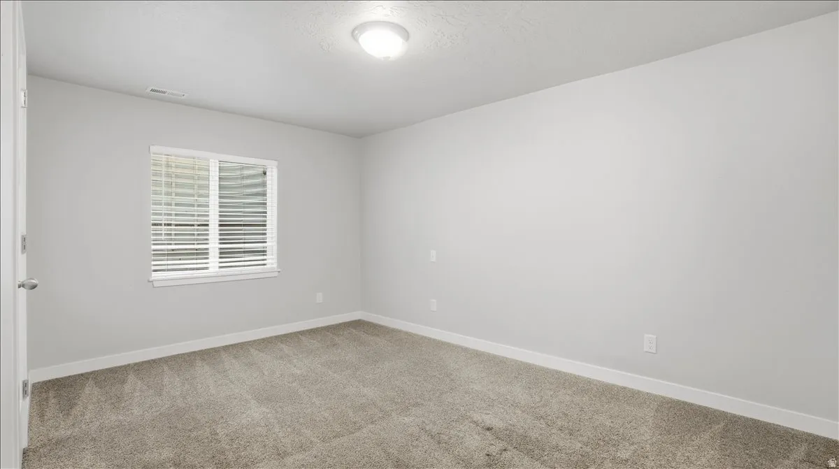 Unfurnished room with baseboards and light carpet