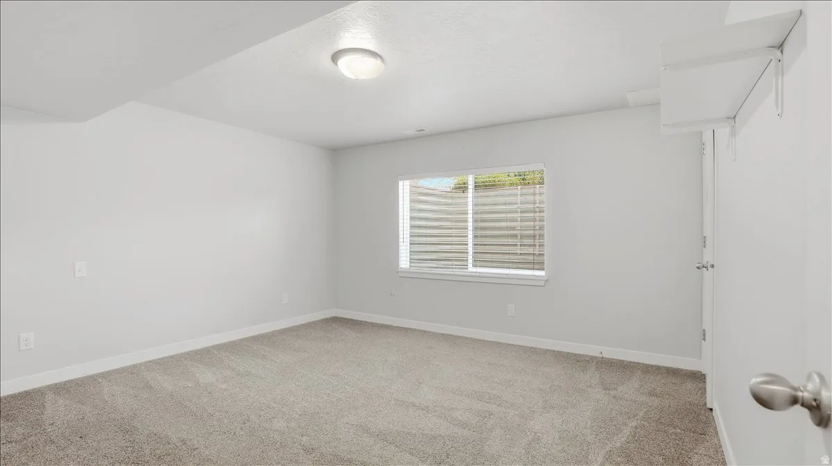 Unfurnished room featuring light colored carpet and baseboards