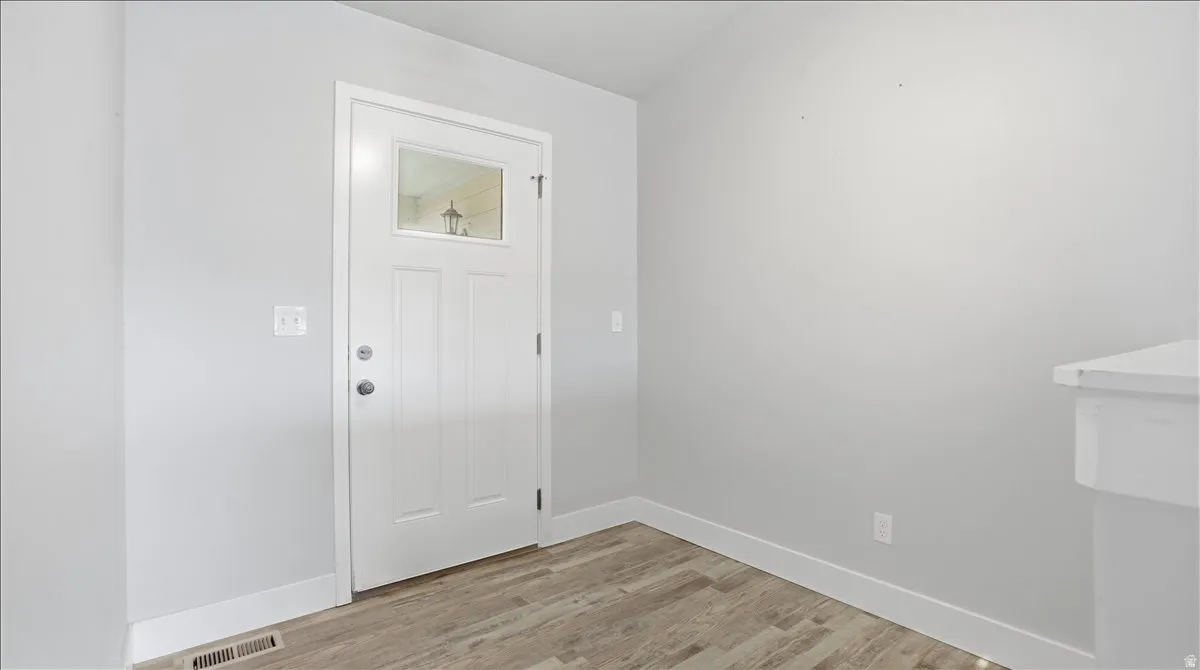 Foyer with light wood-style floors and baseboards