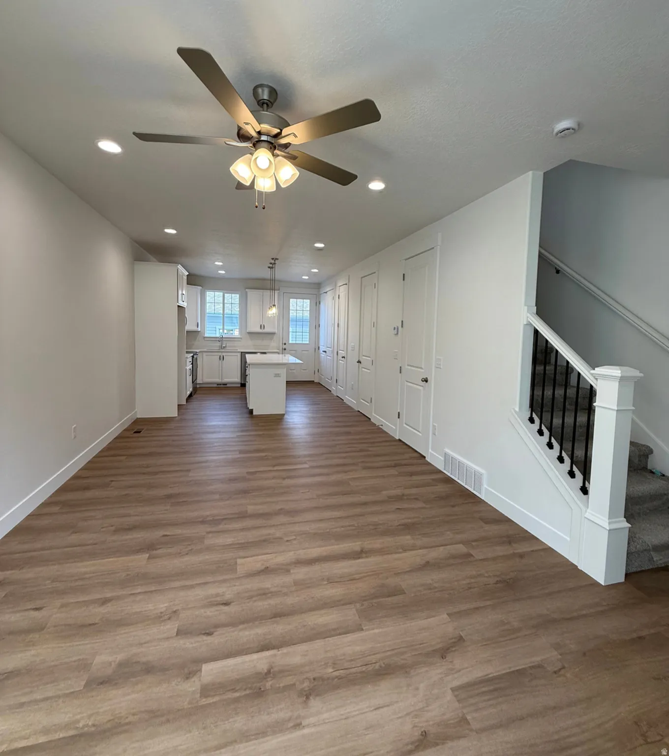 Unfurnished living room featuring dark wood-style flooring, ceiling fan, and recessed lightingPhotos are for reference only.  Actual finishes may vary.
