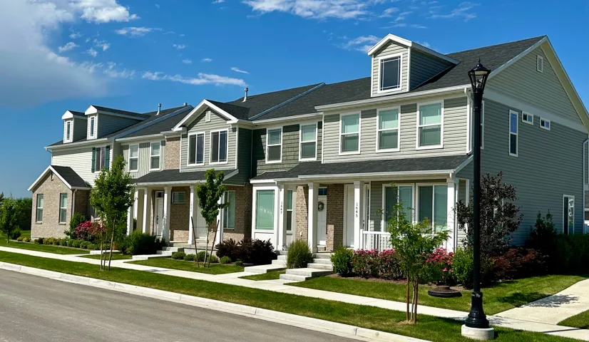 View of front of house with covered porch, a front lawn, a shingled roof, and brick siding