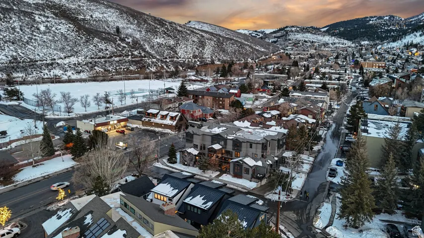 Snowy aerial view featuring a mountain view and a residential view