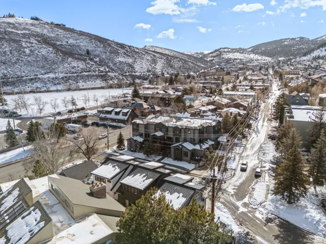 Snowy aerial view featuring a mountain view and a residential view