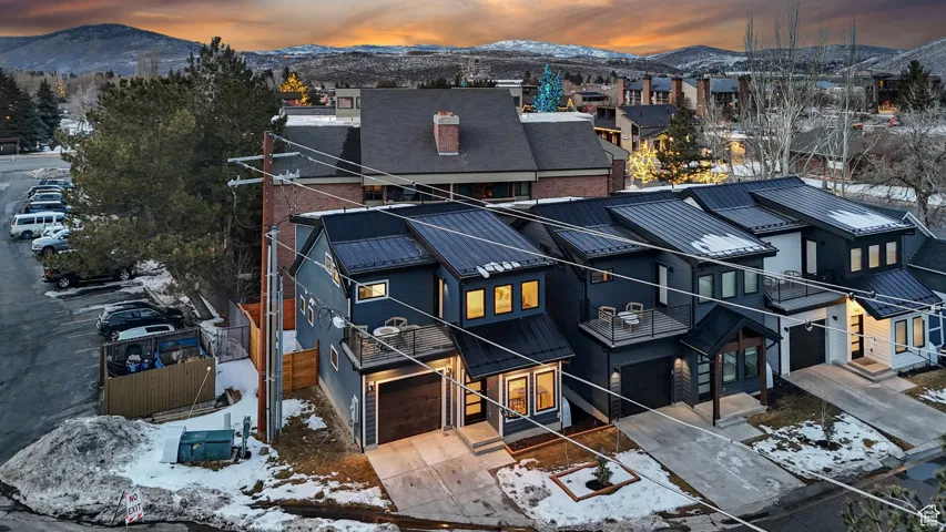Snowy aerial view featuring a mountain view and a residential view