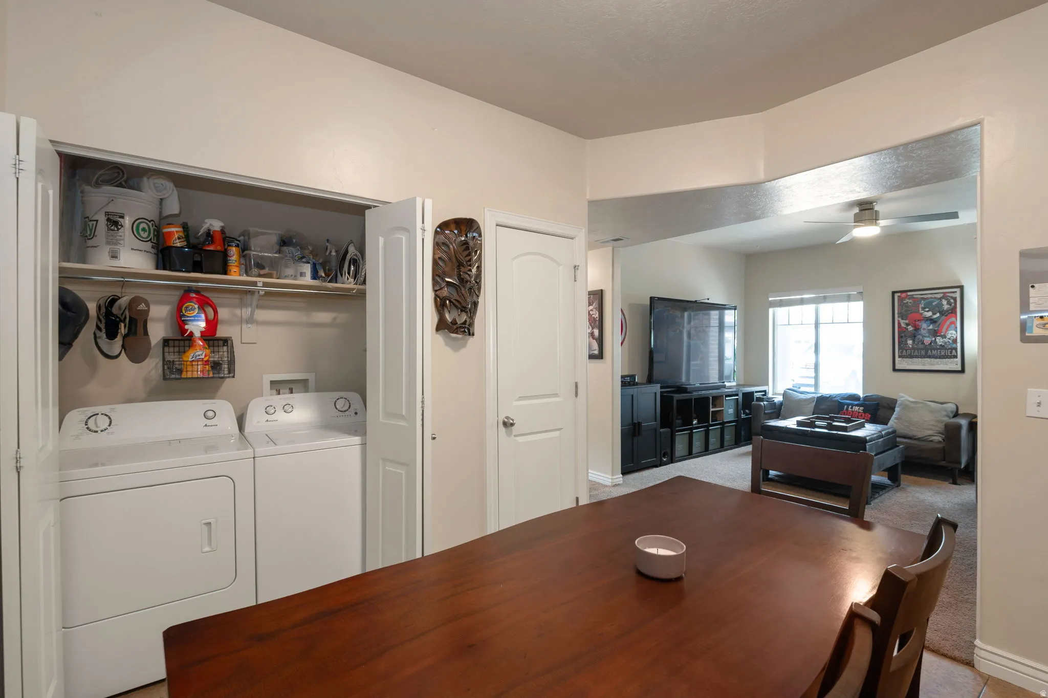 Dining room featuring light carpet, washer and clothes dryer, and a ceiling fan