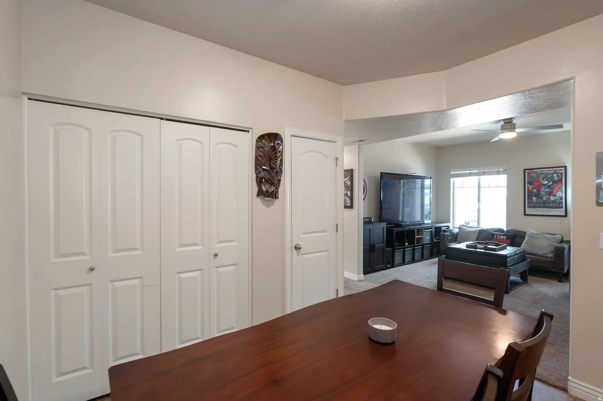 Carpeted dining area featuring ceiling fan and baseboards