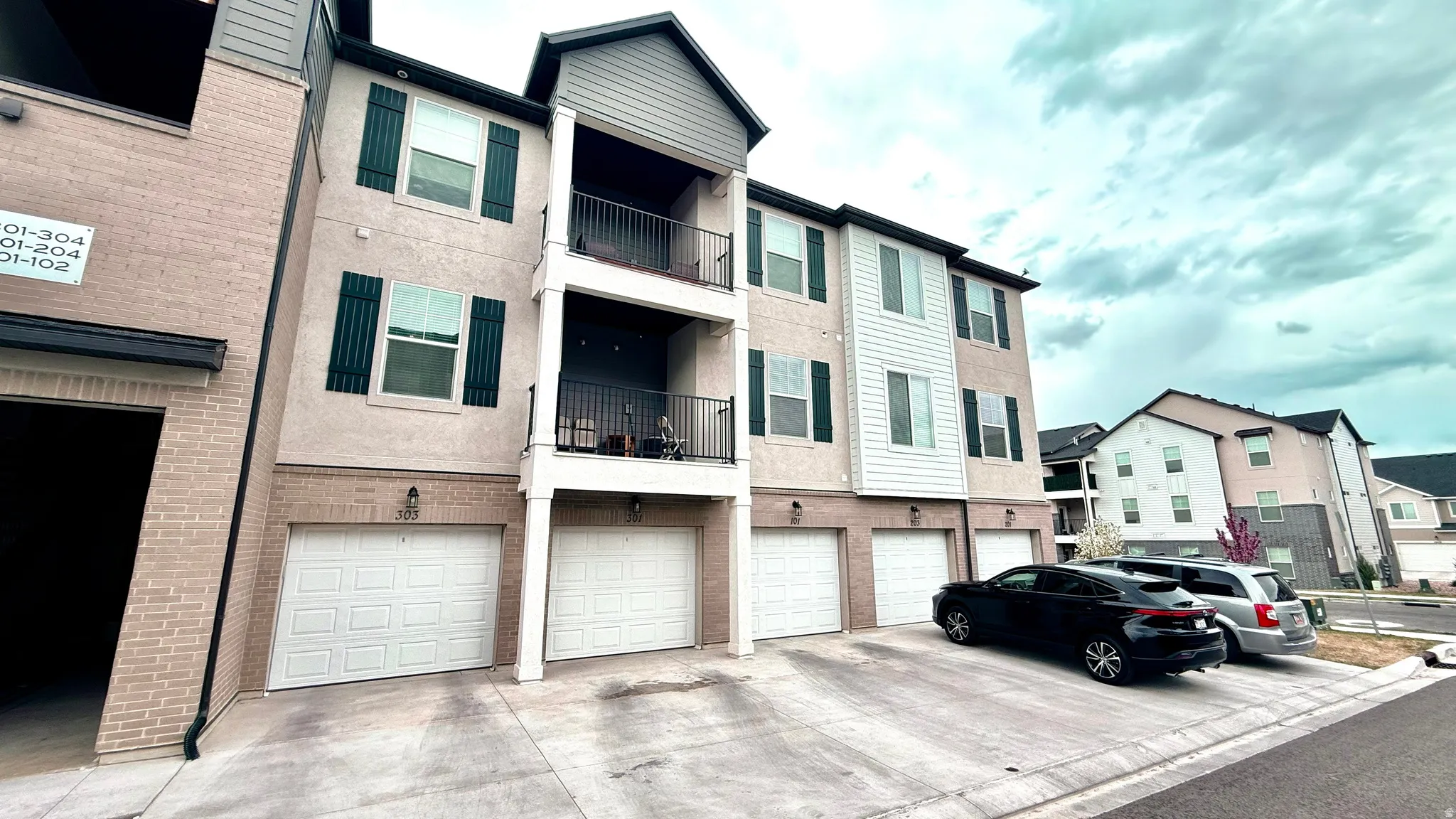View of apartment building / complex with an attached garage and driveway