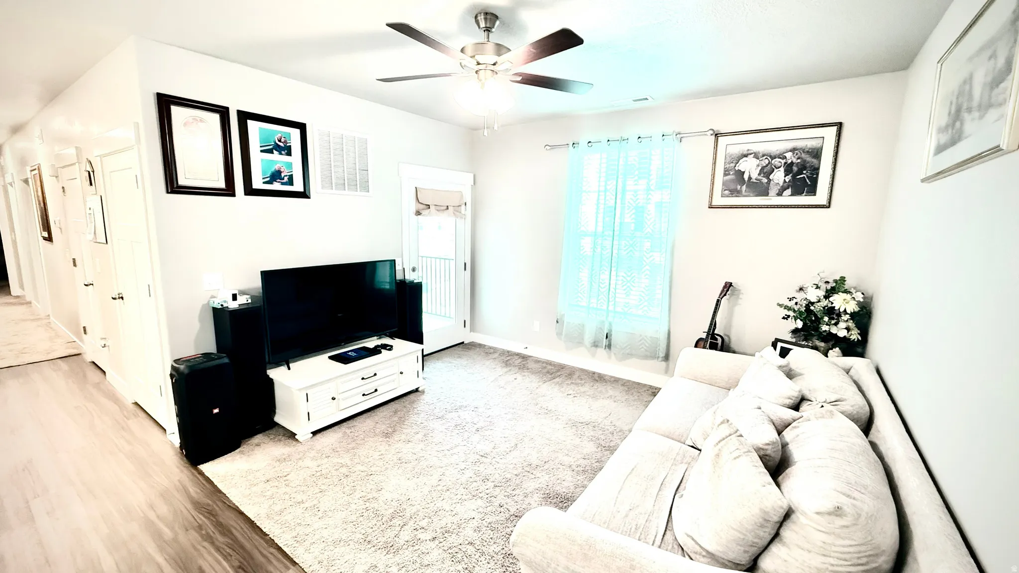 Living area with ceiling fan and light wood-style floors
