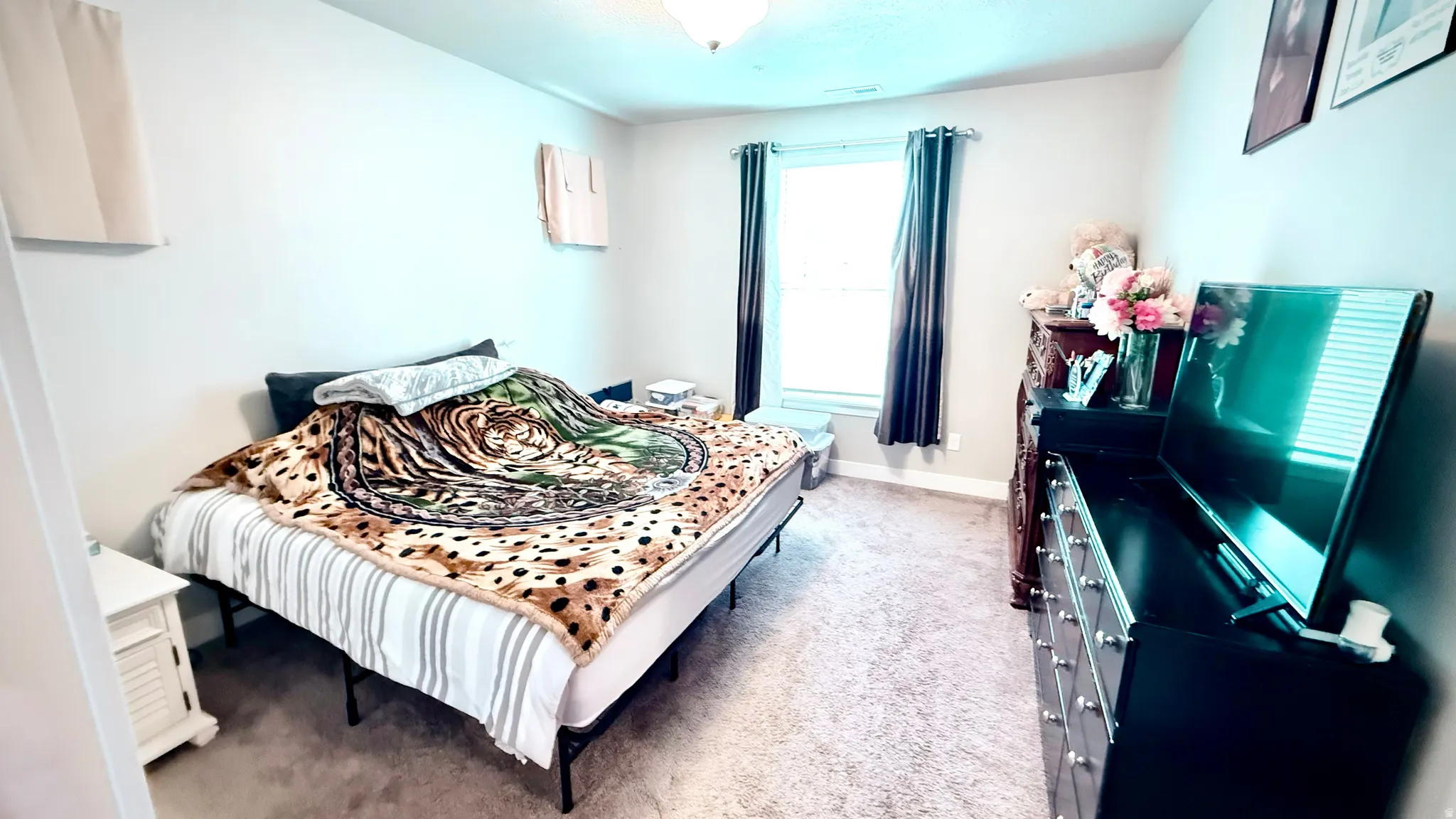 Bedroom with light colored carpet and baseboards