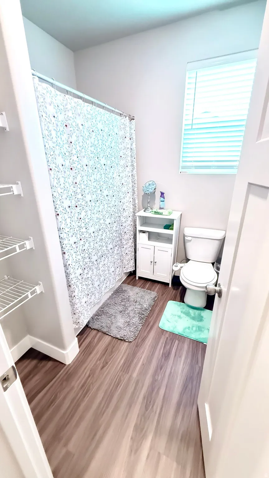 Bathroom featuring a shower with shower curtain and dark wood finished floors