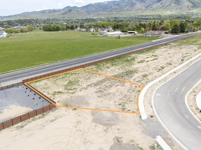 Aerial view of property and surrounding area with a mountain backdrop and property boundaries highlighted