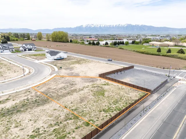 Aerial view of residential area with property parcel outlined and a mountain backdrop