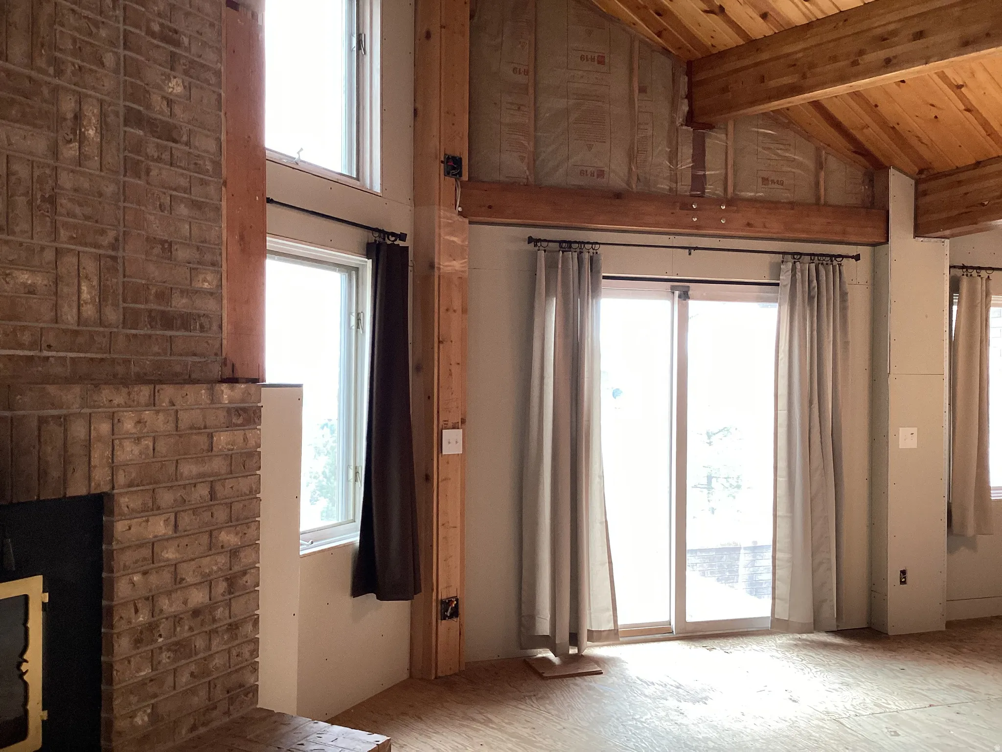Unfurnished living room featuring a high wood beamed ceiling