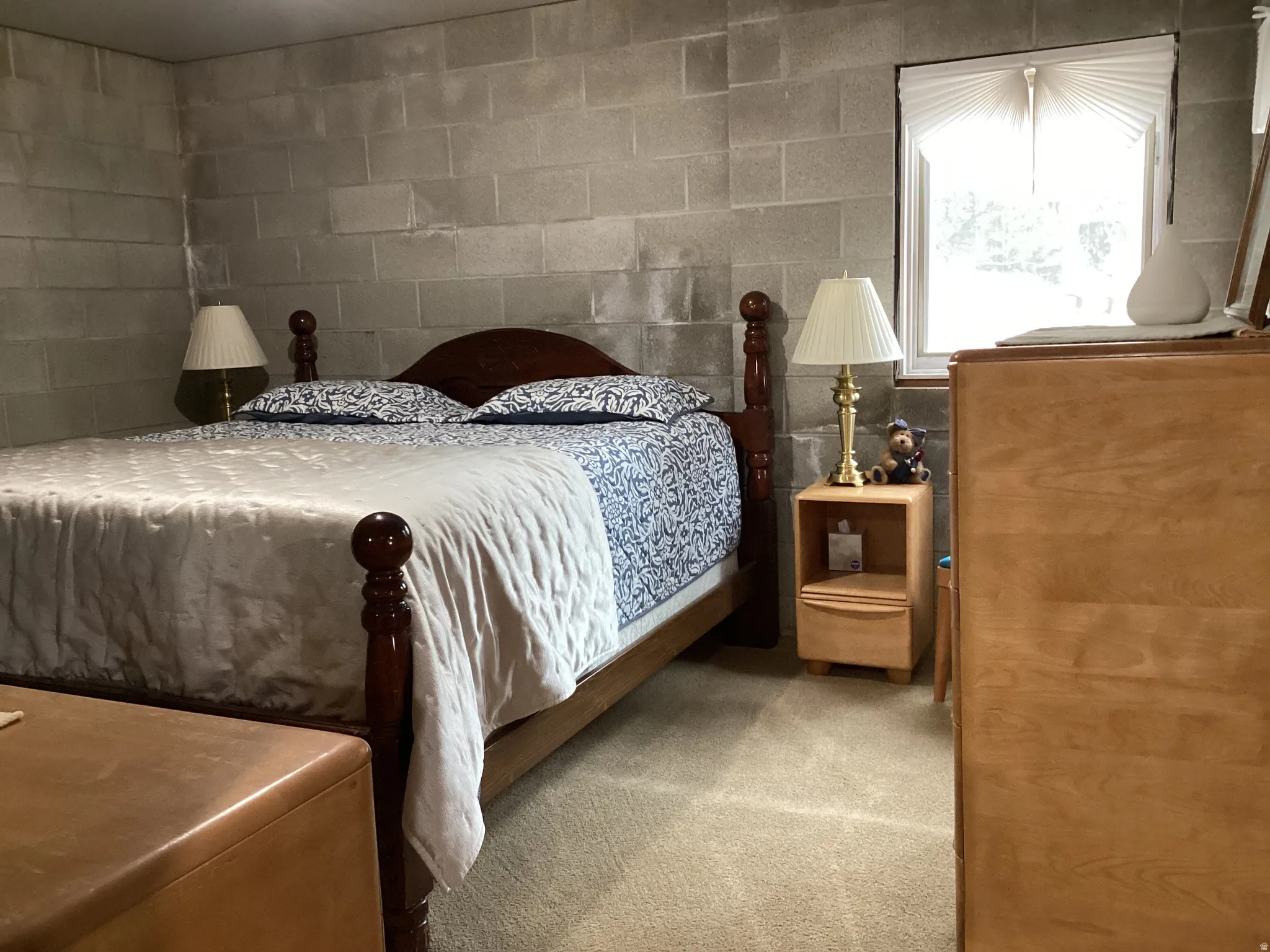 Carpeted bedroom featuring concrete block wall