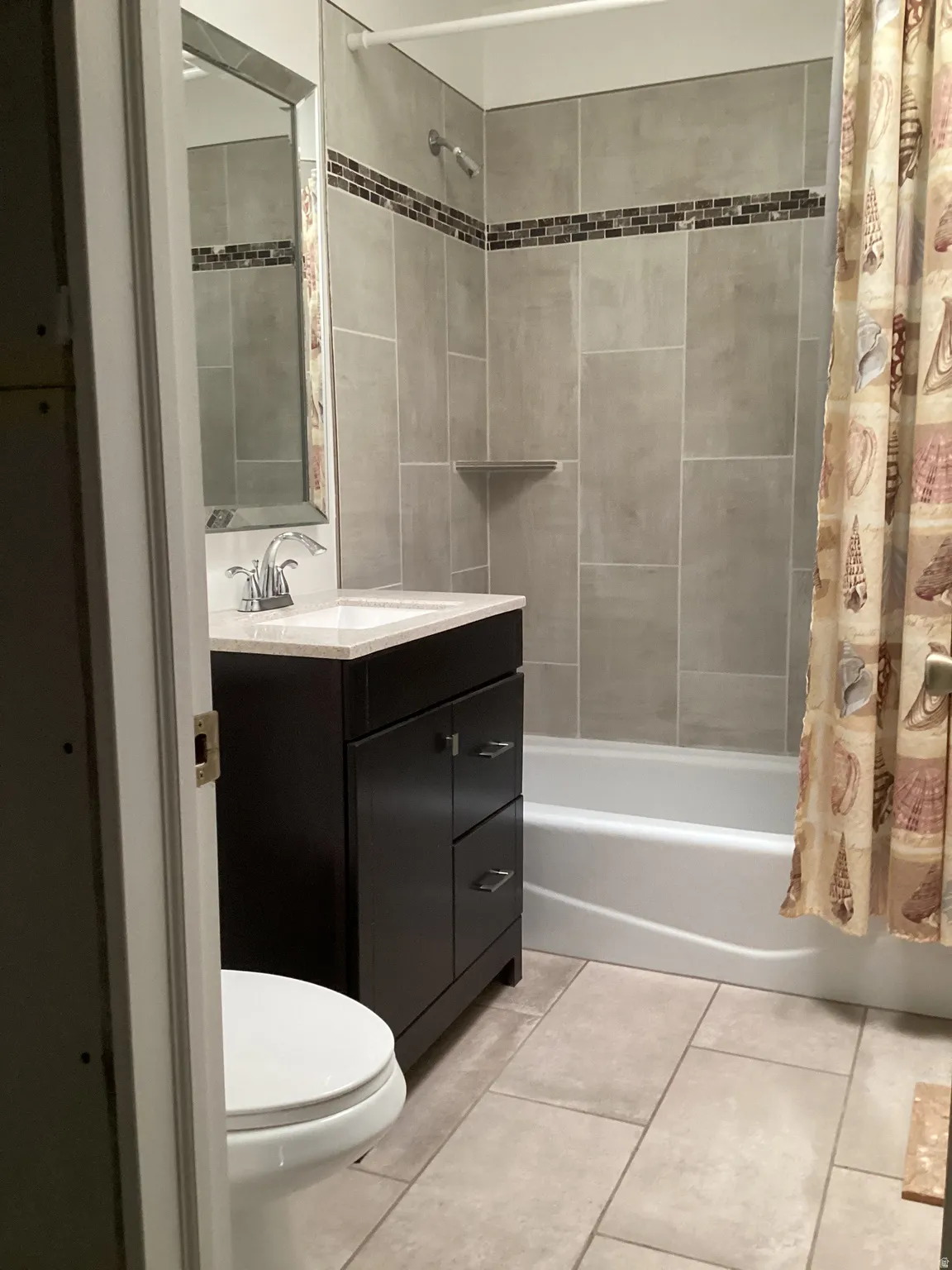 Full bath with vanity, shower / bath combination with curtain, and light tile patterned floors