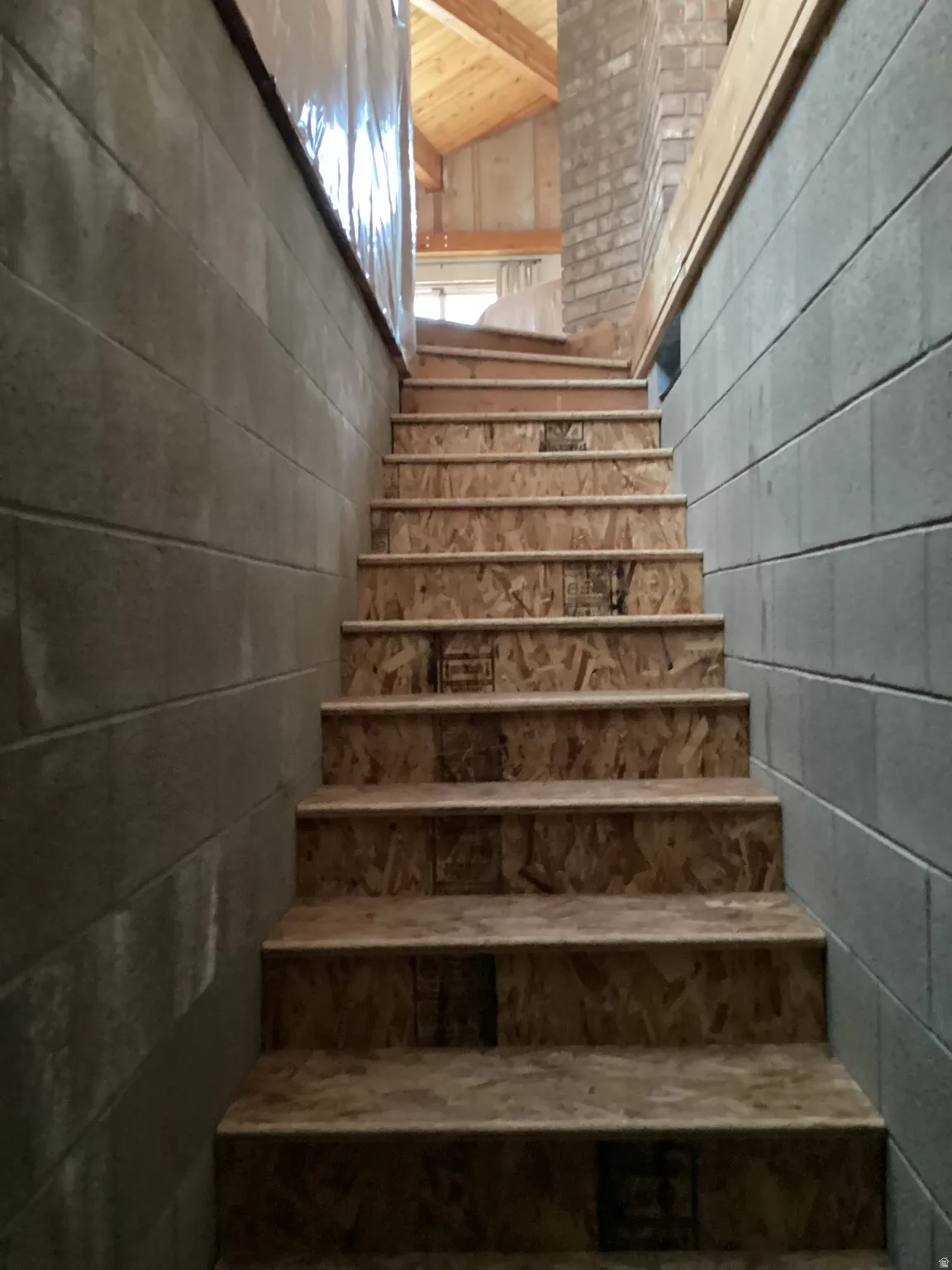 Stairway featuring concrete block wall