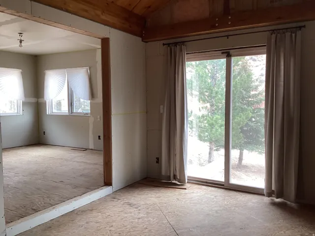 Unfurnished room featuring lofted ceiling