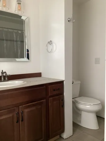 Bathroom featuring vanity, light tile patterned floors, and a shower with shower curtain