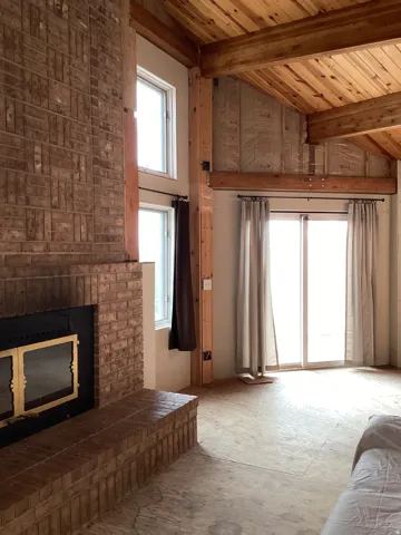 Unfurnished living room with lofted ceiling and a fireplace