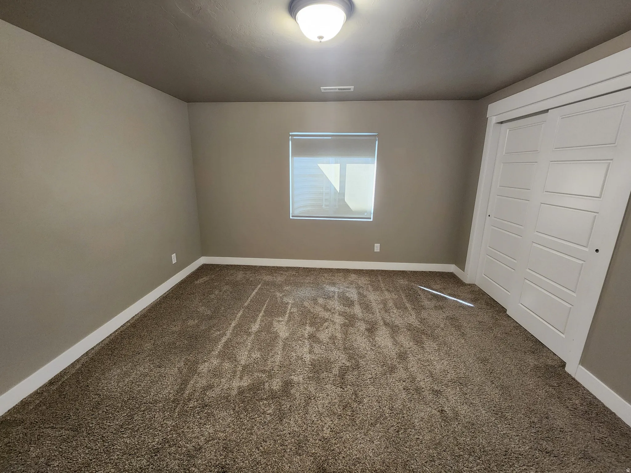 Unfurnished bedroom featuring a closet and dark colored carpet