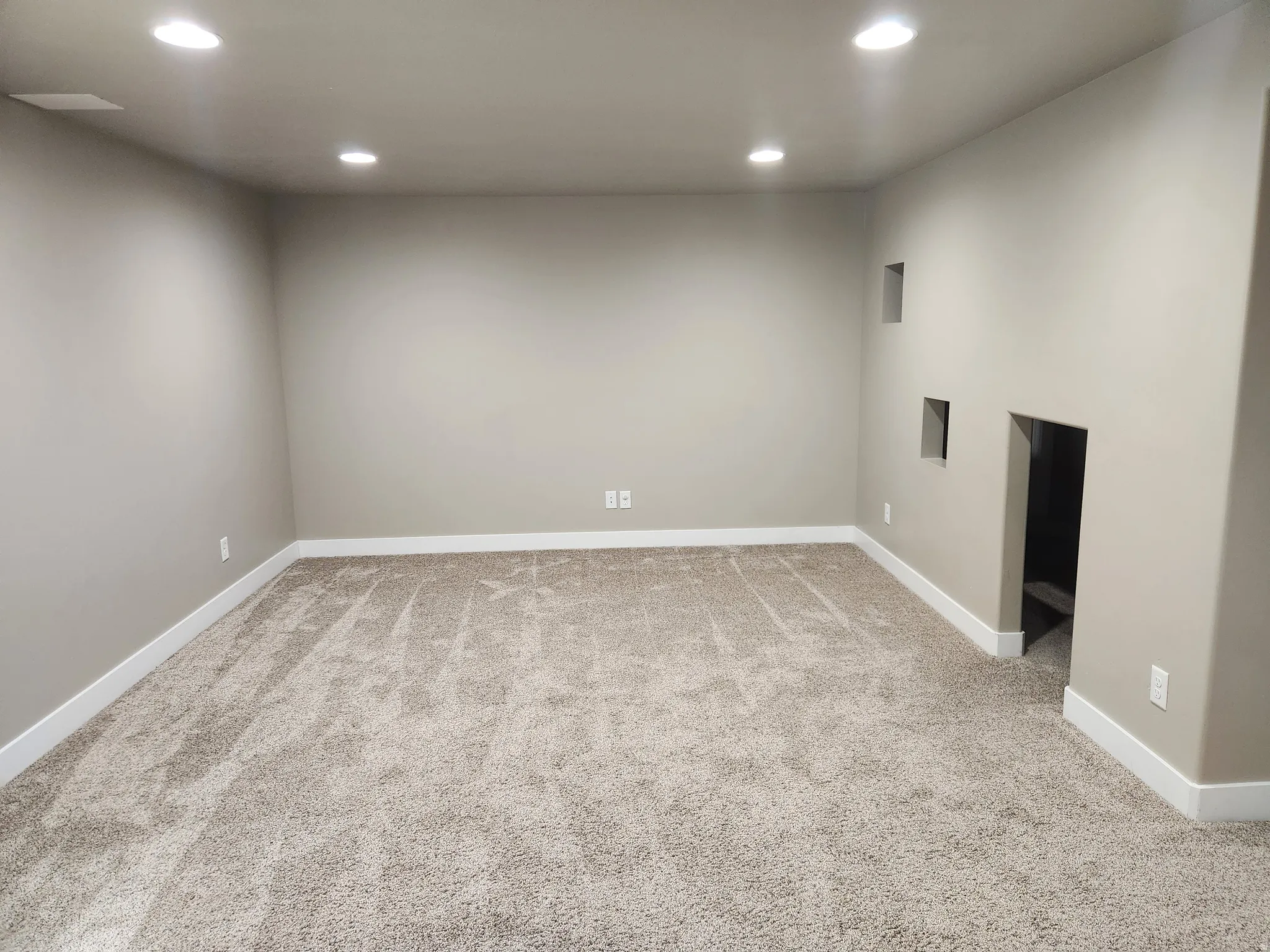 Empty room with recessed lighting and light colored carpet