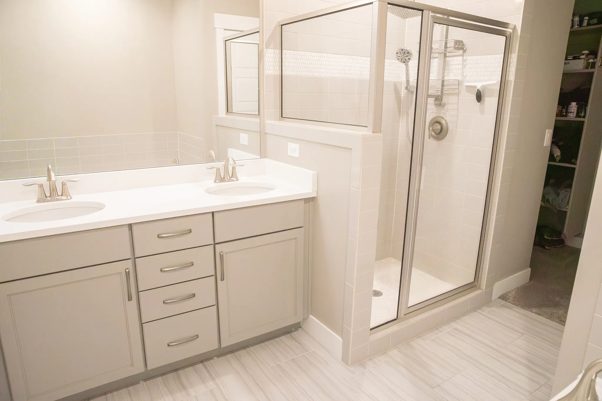 Full bath with double vanity and a shower stall