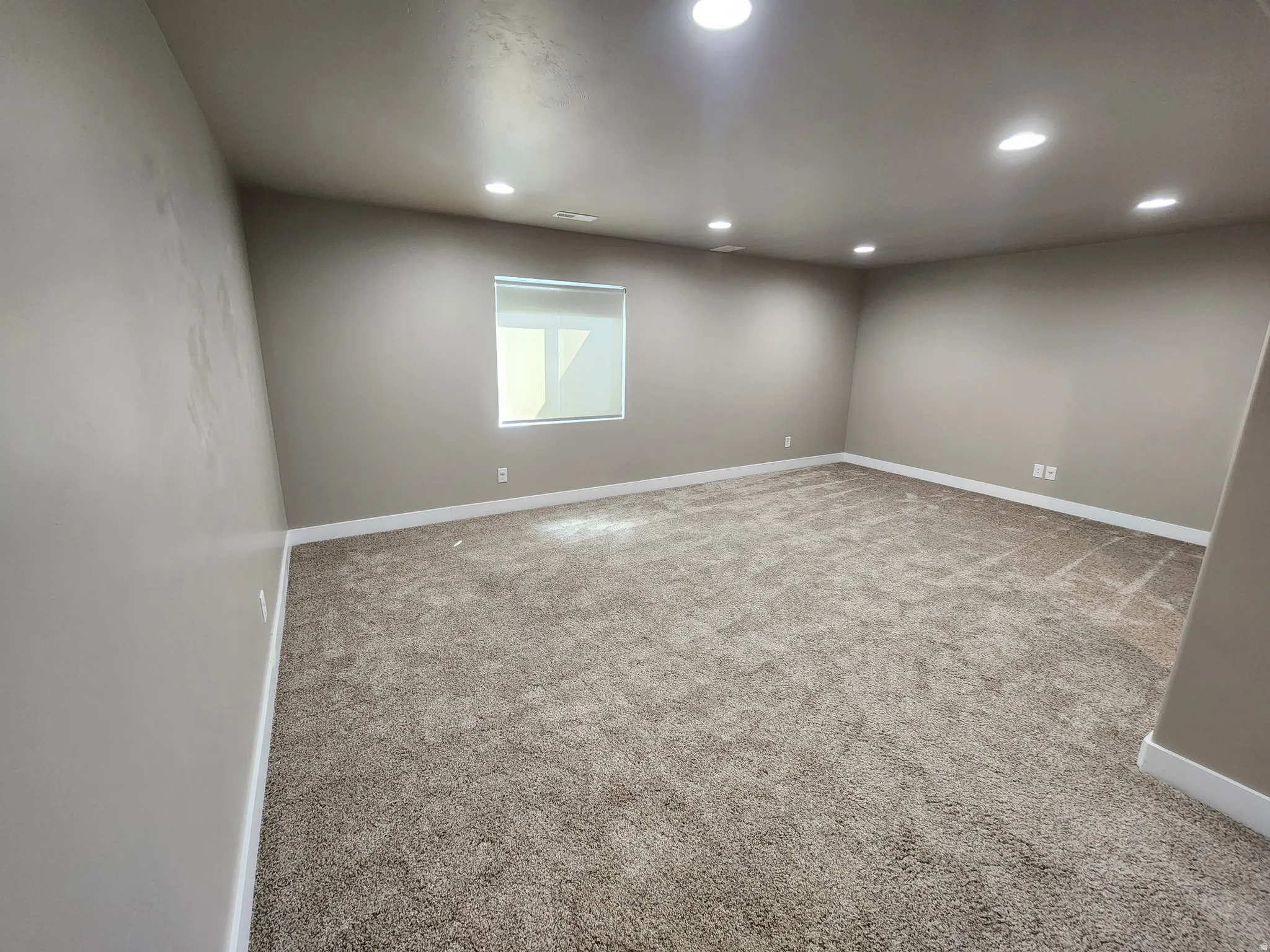 Empty room featuring light colored carpet and recessed lighting