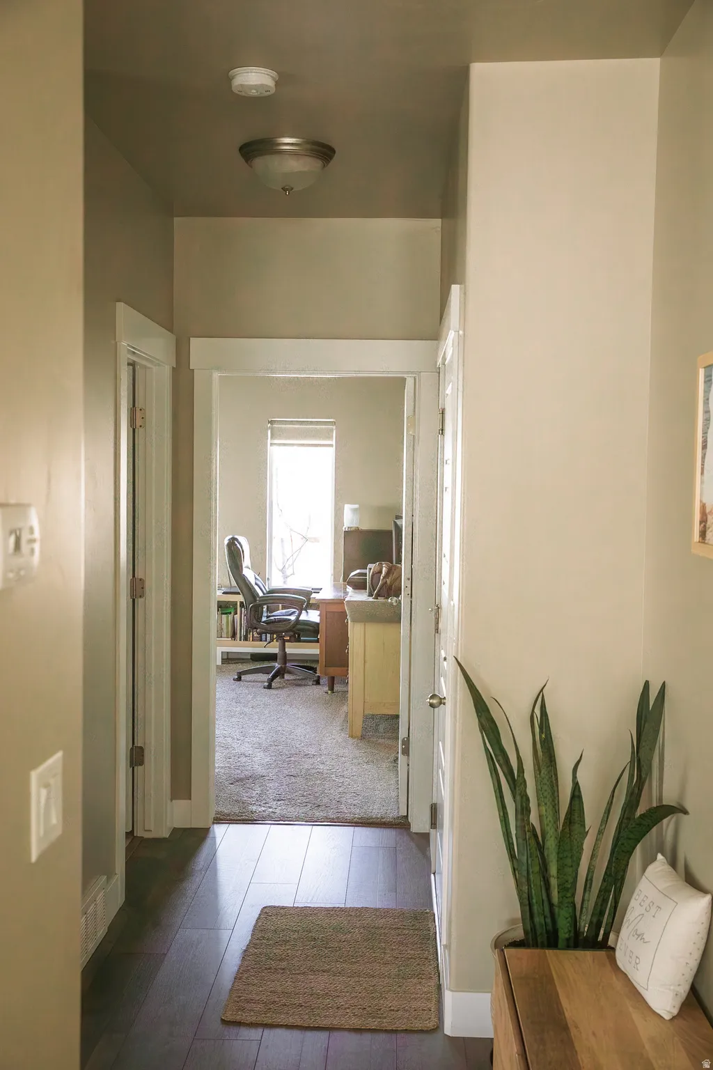 Hallway featuring an office area and dark wood-type flooring