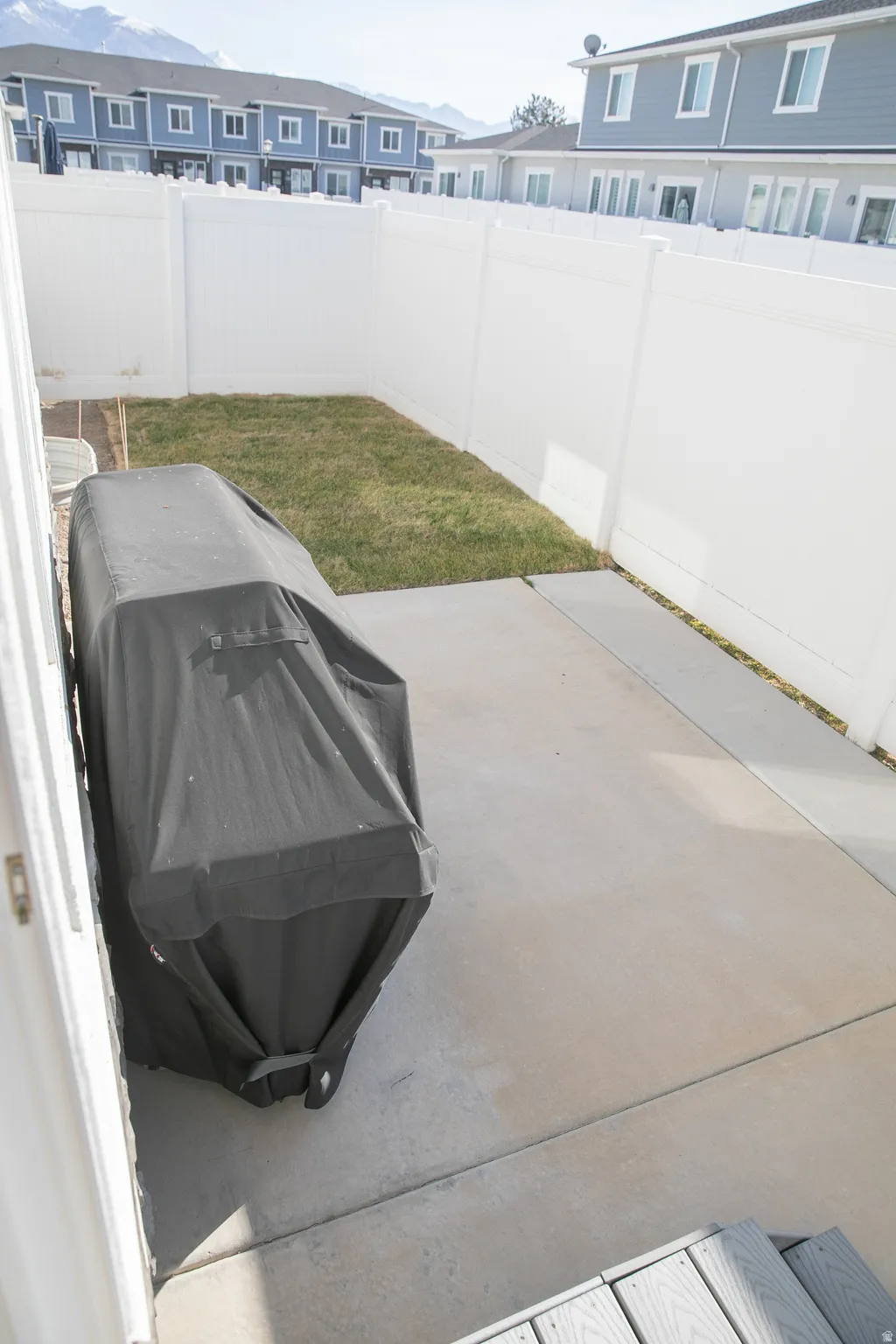 Fenced backyard featuring grilling area, a patio area, and a residential view