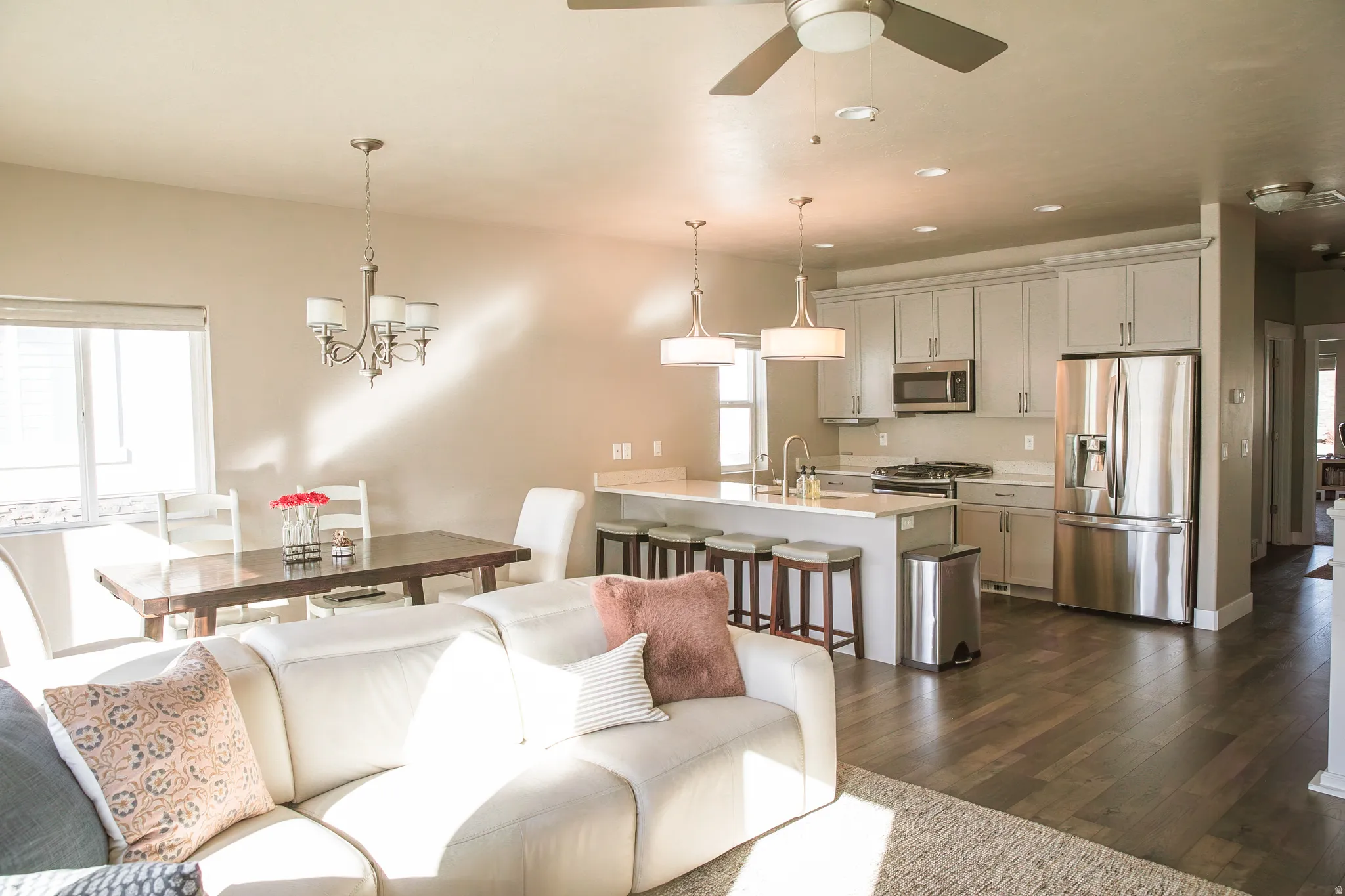 Living room with dark wood finished floors, a ceiling fan, and hanging lights