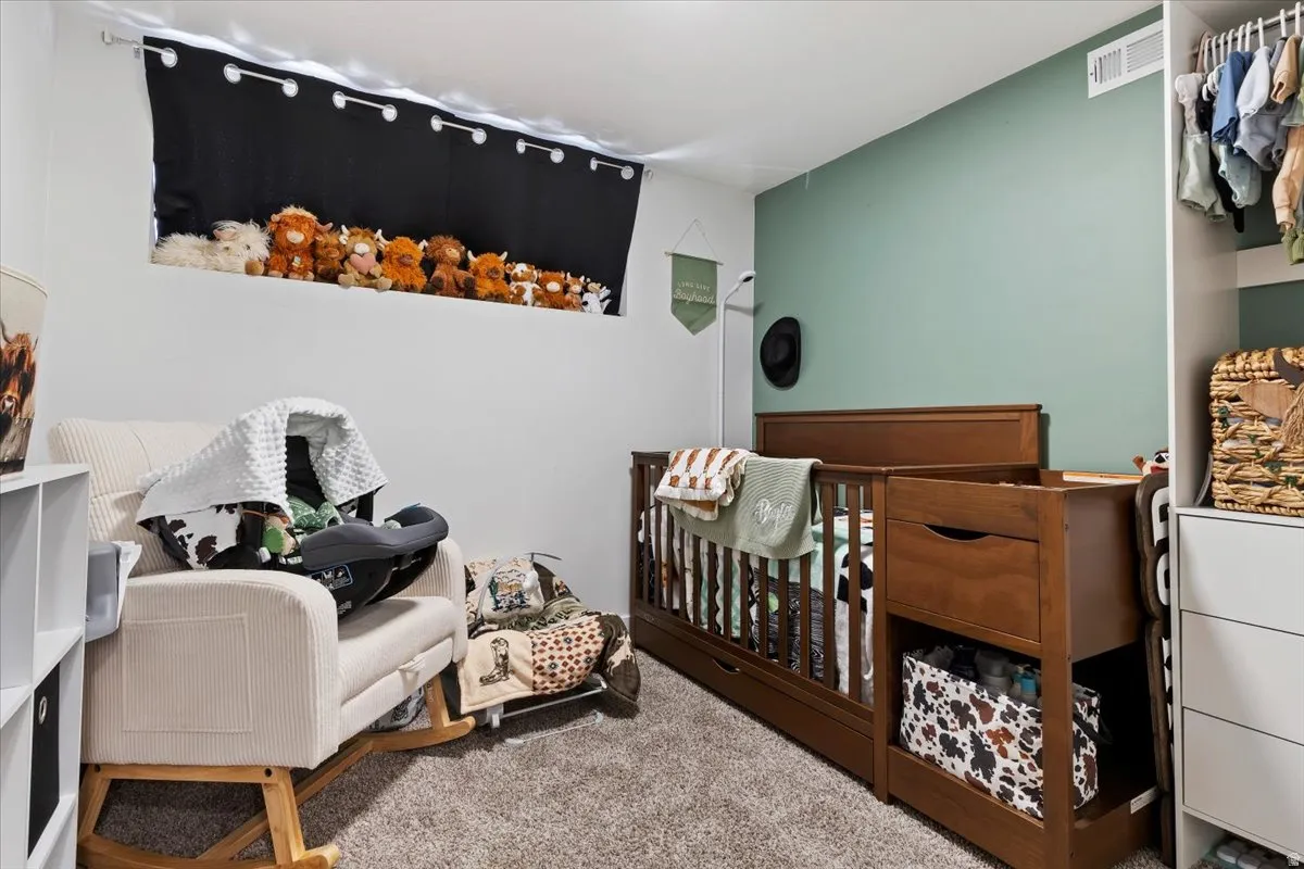 Bedroom featuring a crib and carpet