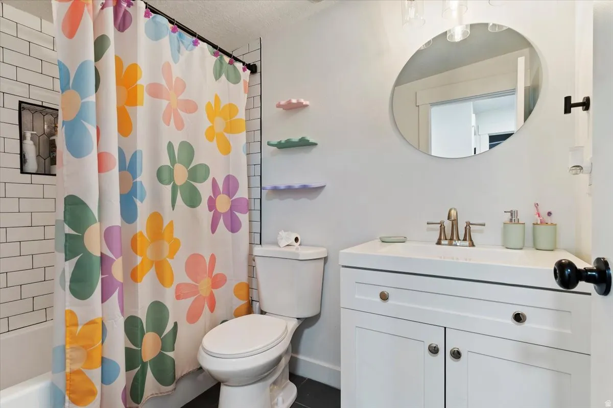 Bathroom featuring vanity and shower / bathtub combination with curtain