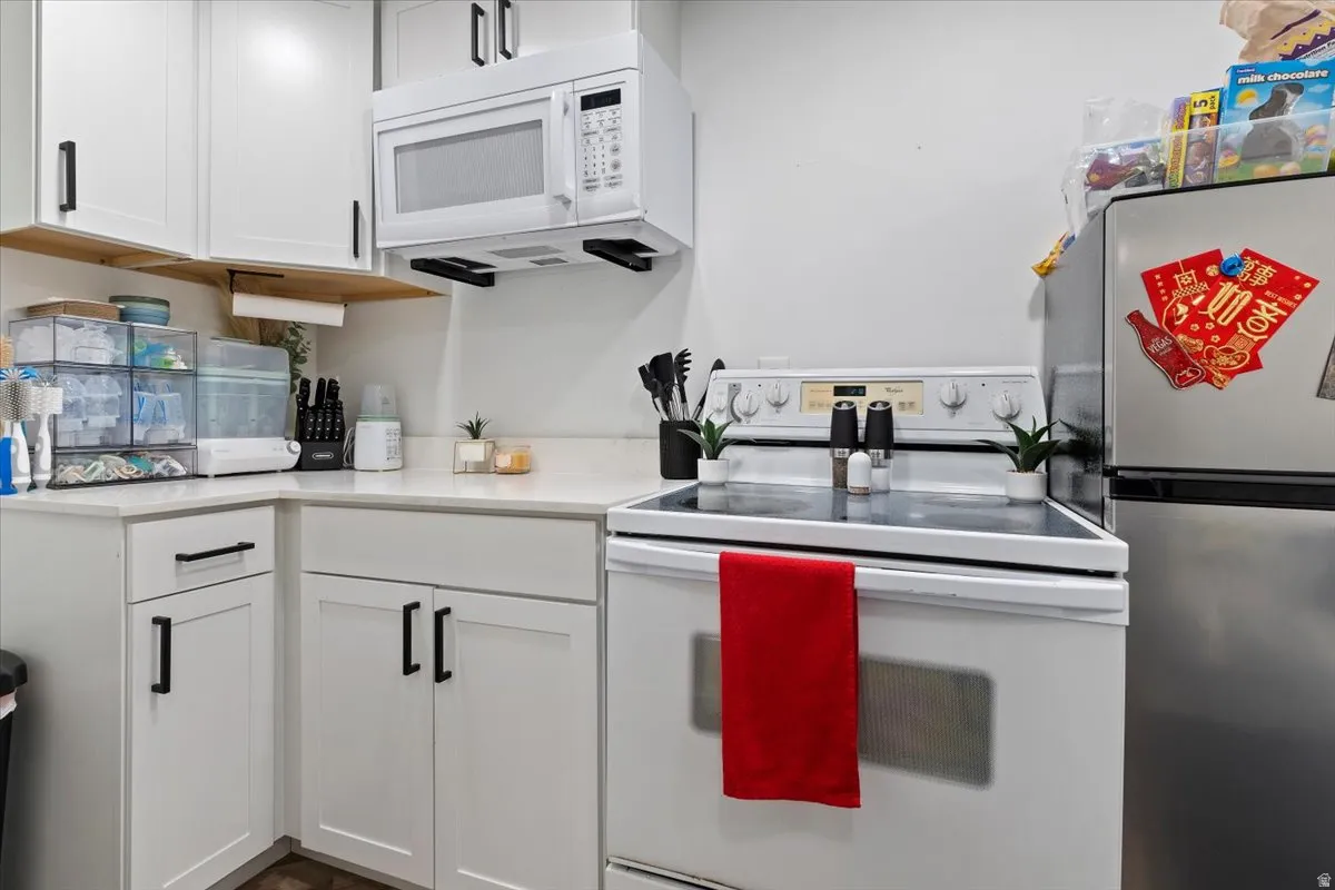 Kitchen with white appliances and white cabinetry