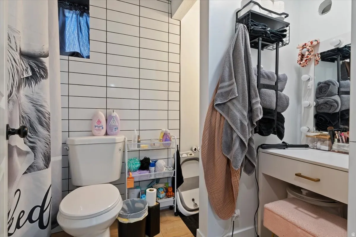Bathroom featuring tile walls, a shower with shower curtain, and light wood-type flooring