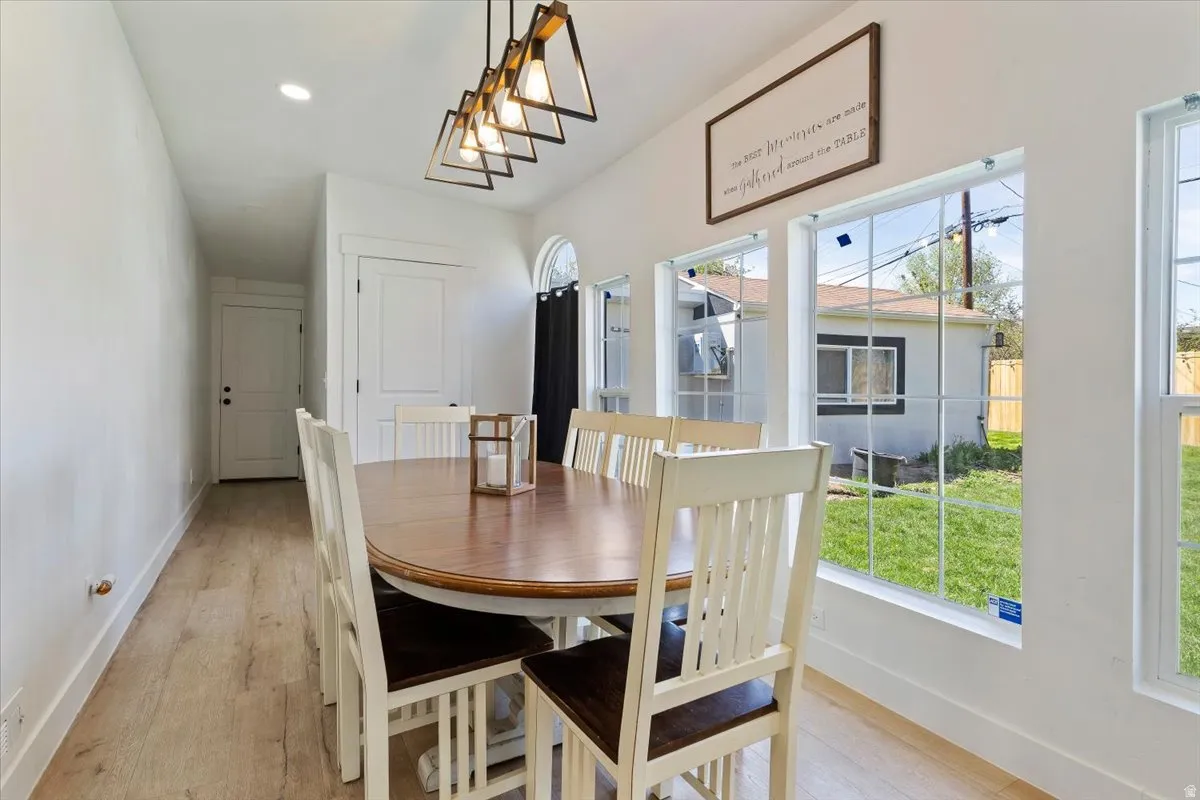 Dining area with light wood-style floors and recessed lighting